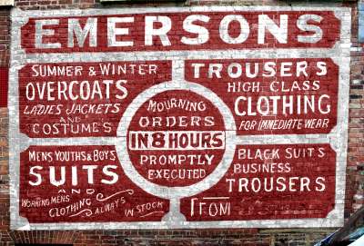 Old sign still on the wall of a former high street tailors shop in 2007
