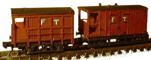 Photo of two small brake vans in Fettling-on-sea to Tethers End Light Railway livery